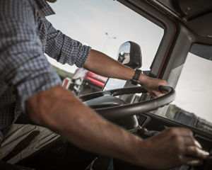 person driving a truck with hands on the steering wheel showing six important driving techniques